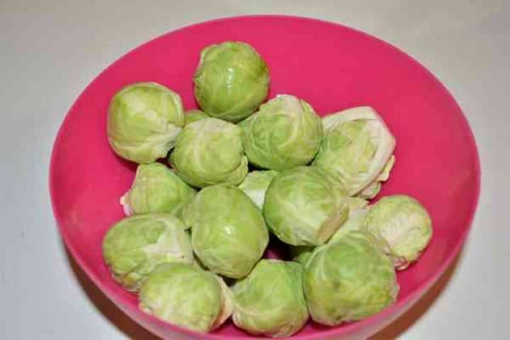 Brussels Sprouts With Lemon-Brussels Sprouts, Bacon, Lemon and Chives on the Table Freshly washed and trimmed whole green Brussels sprouts in a bowl.