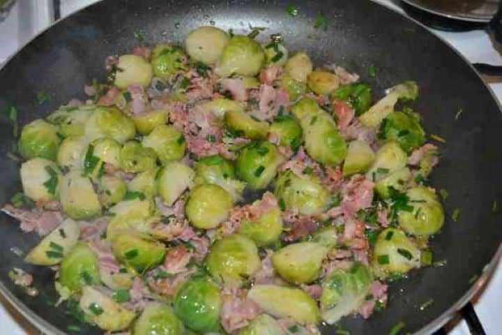 Brussels Sprouts With Lemon-Boiled Brussels Sprout on the Fried Bacon Cooked Brussels sprouts tossed with grated lemon zest, lemon juice, smoked bacon, and chopped chives in a skillet.