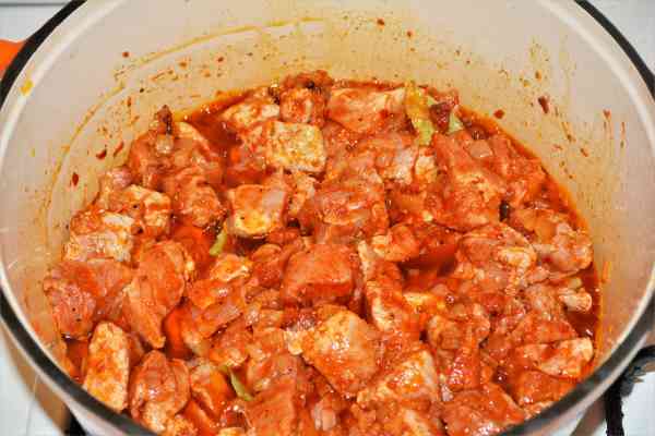 Pork and Sauerkraut Goulash-Frying Pork Cubes With Chopped Onions and Smoked Bacon in the Dutch Oven