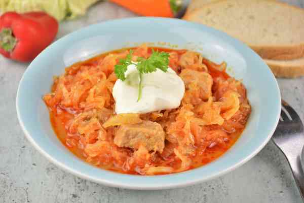 Pork and Sauerkraut Goulash-Served on Plate With Sour Cream on Top