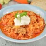 Pork and Sauerkraut Goulash Served on Plate With Sour Cream on Top