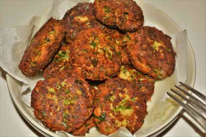 Zucchini Balls Recipe-Fried Zucchini Balls in the Bowl Ready to Serve Golden brown fried zucchini balls draining on a paper towel in a bowl.