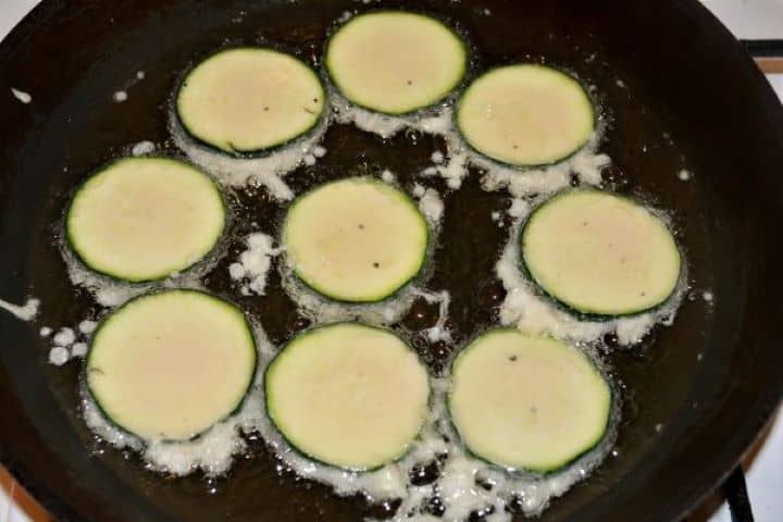Battered Fried Zucchini-Frying Battered Zucchini Slices in the Frying Pan Battered zucchini slices shallow-frying in hot sunflower oil in a skillet.