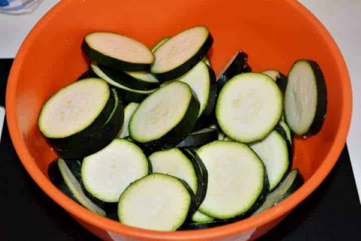 Battered Fried Zucchini-Salted Sliced Zucchini in the Bowl Sliced zucchini tossed with coarse sea salt in a bowl to draw out excess liquid.