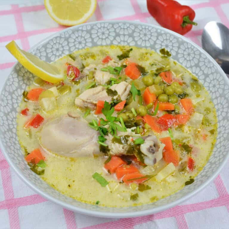 Creamy Chicken Soup With Vegetables-Chicken and Vegetable Soup Served in Bowl With Lemon Slice and Chilli Peppers