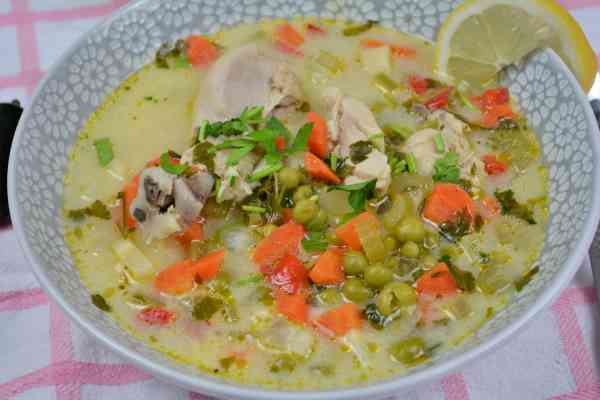 Creamy Chicken Soup With Vegetables-Chicken and Vegetable Soup Served in Bowl With Lemon Slice and Chilli Peppers