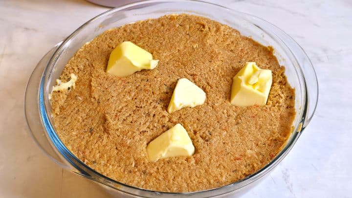 Meatloaf Pate Recipe-Meat Paste in the Glass Baking Tray Meat and Vegetables Spread in the Glass Dish With Butter on Top