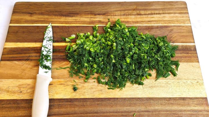 Hungarian Stuffed Peppers-Chopping the Dill on Chopping Board Chopped Dill on the Cutting Board