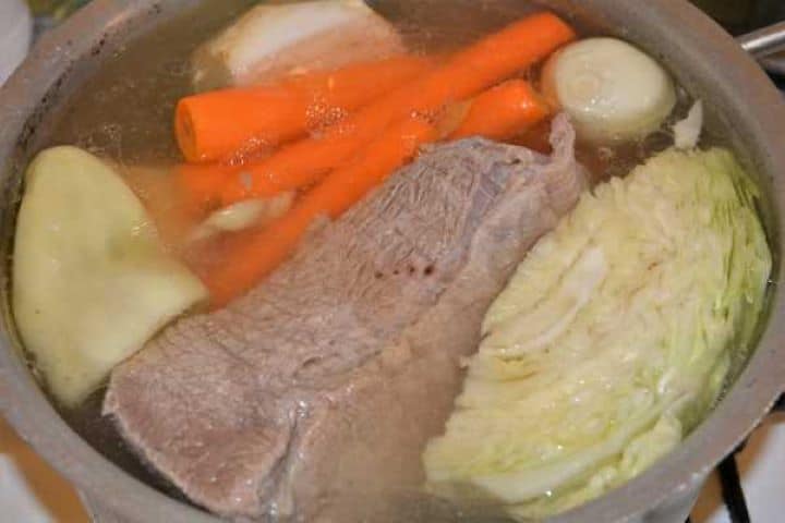 Semolina Dumplings Soup-Boiling Beef and Vegetables in the Pot Beef and whole root vegetables simmering gently on low heat in a stockpot.