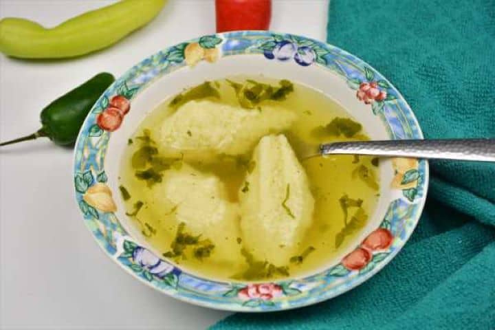 Semolina Dumplings Soup-Served in Bowl With Chilli Peppers Aside Fluffy Hungarian semolina dumplings in clear beef broth served with sliced carrots.