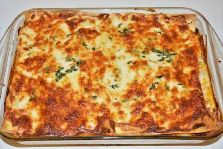 Turkey Lasagna With White Sauce-Baked Dish Ready to Serve Golden bubbly baked turkey lasagna with melted mozzarella in a glass baking dish.
