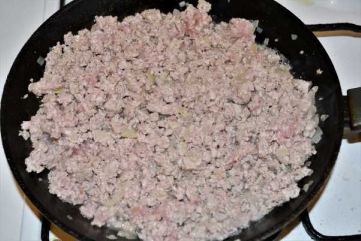 Turkey Lasagna With White Sauce-Fried Ground Turkey and Chopped Onions in the Frying Pan Ground turkey browning and breaking into crumbles with onions in a skillet.