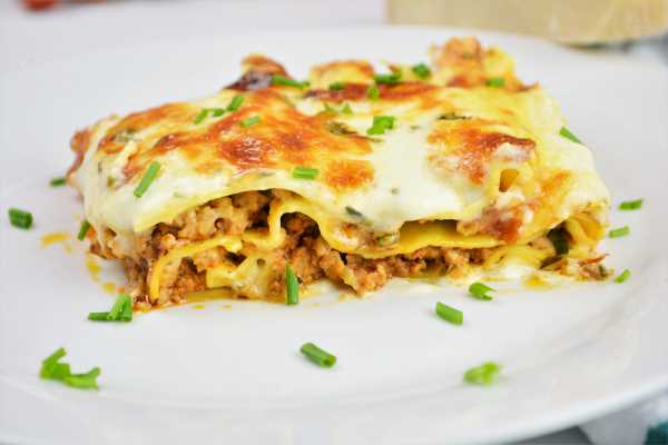Turkey Lasagna With White Sauce-Lasagna Slice Served on Plate With Chopped Chives on Top