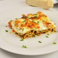 Turkey Lasagna With White Sauce-Lasagna Slice Served on Plate With Chopped Chives on Top