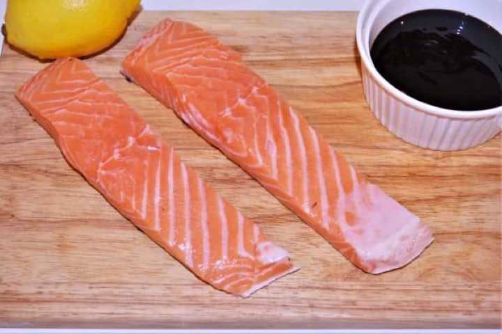 Ingredients Salmon Fillet, Teriyaki Sauce and Lemon on the Chopping Board