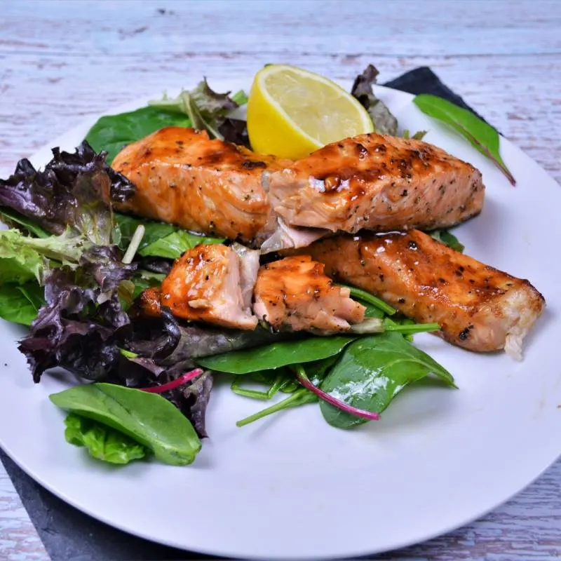 Air Fryer Teriyaki Salmon-Served on Plate With Salad Mix and Lemon