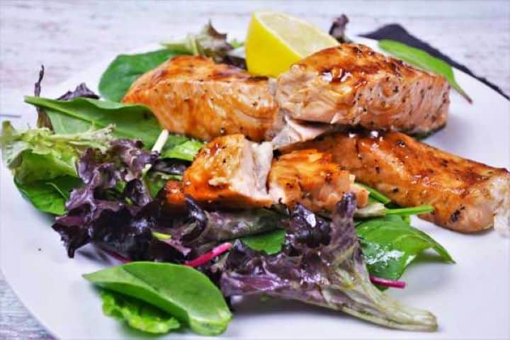 Serving Air Fryer Teriyaki Salmon Served on Plate With Salad Mix and Lemon