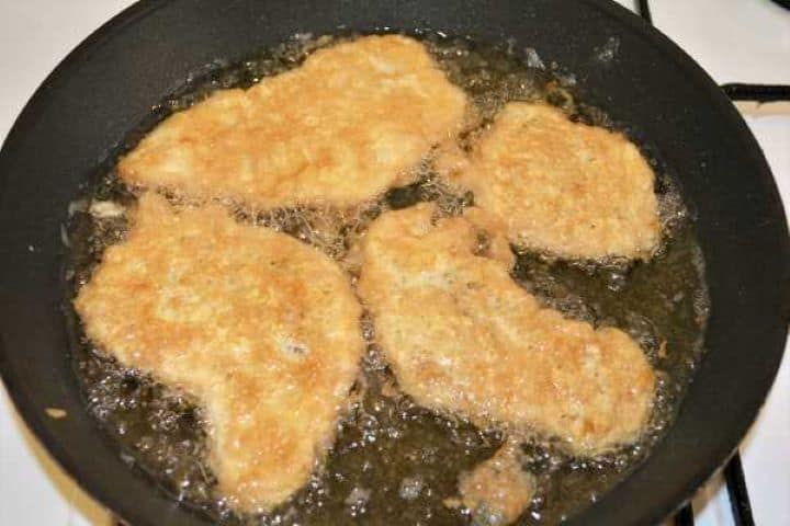 Turkey Schnitzel Recipe-Fried Battered Turkey Slices in the Pan Turkey schnitzels turning puffed and golden brown while frying on medium heat.
