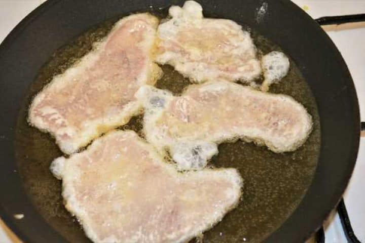 Turkey Schnitzel Recipe-Frying Battered Turkey Slices in the Pan Coated turkey cutlets frying in hot sunflower oil in a large skillet.