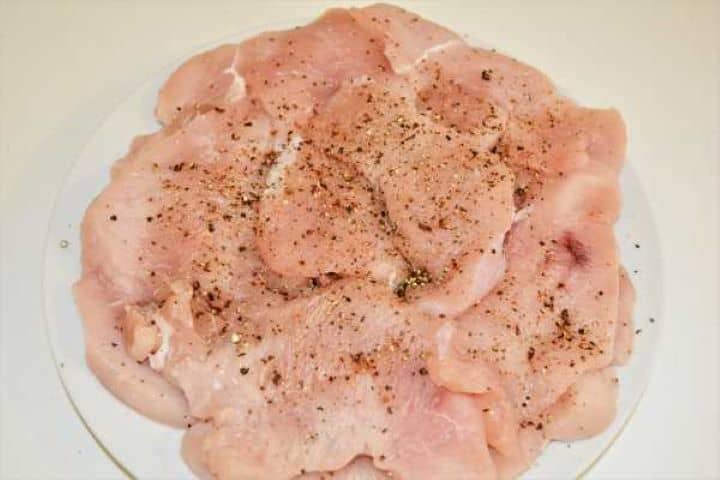 Turkey Schnitzel Recipe-Seasoned Sliced Turkey Breast on the Plate Raw turkey cutlets seasoned evenly with sea salt and freshly cracked black pepper.