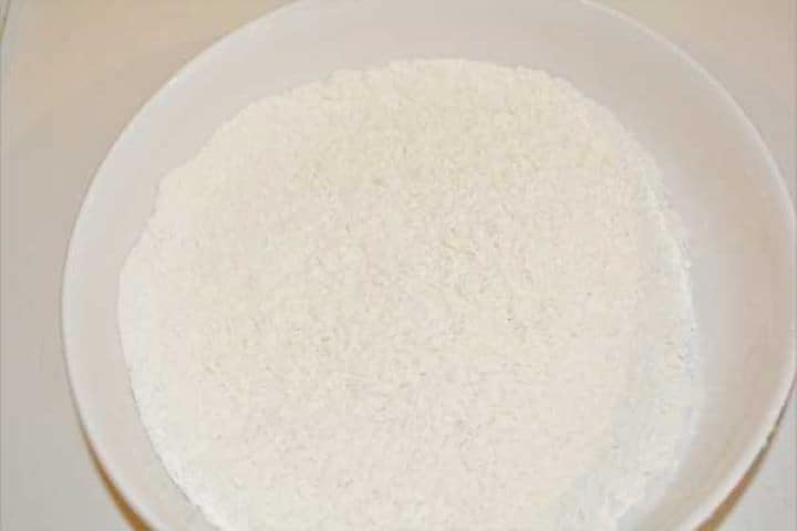 Self-raising wheat flour in a shallow bowl for dredging turkey cutlets.