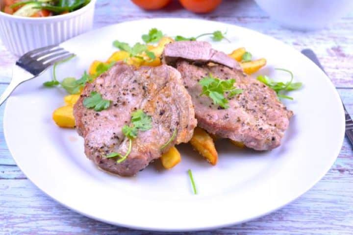 Pork Steak in Air Fryer-Served on Plate With French Fries Tender air fryer pork steak served alongside crispy french fries and homemade garlic cream mujdei.