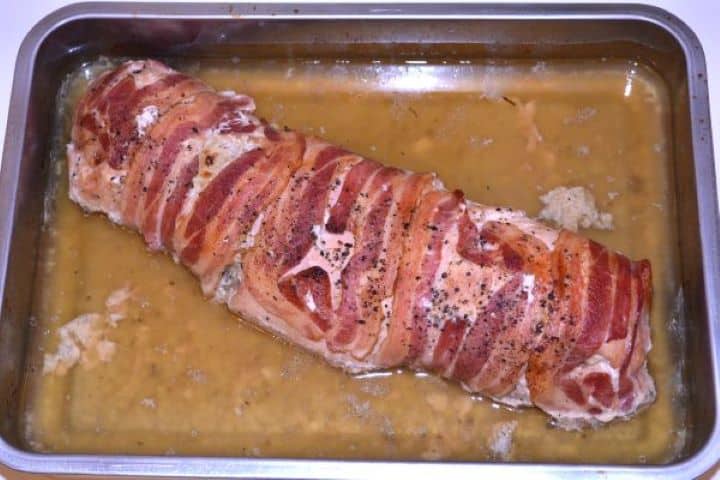 Stuffed Turkey Tenderloin Recipe-Roasted Turkey Roll Ready to Serve in the Baking Dish Fully baked stuffed turkey tenderloin with crispy, deep copper-brown smoked bacon crust in the pan.