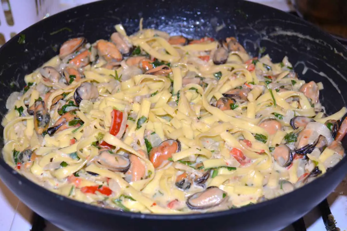 Frozen Mussels Recipe-Shelled Mussels With Tagliatelle Pasta in Cream and White Wine Sauce Ready to Serve in the Pan