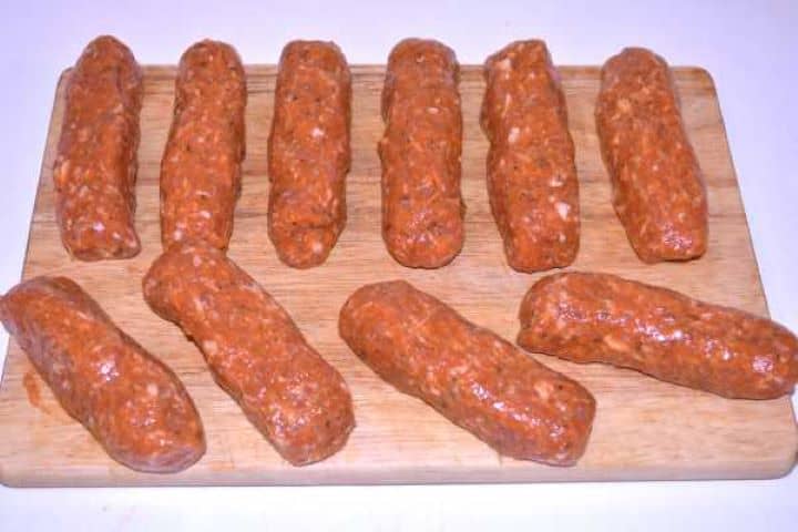 Rolled Mince Tray of uncooked homemade skinless sausages shaped into neat cylinders ready for the grill or skillet.