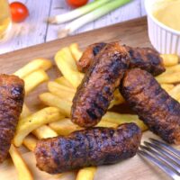 Skinless Sausages-Served With Fries and Mustard on the Chopping Board