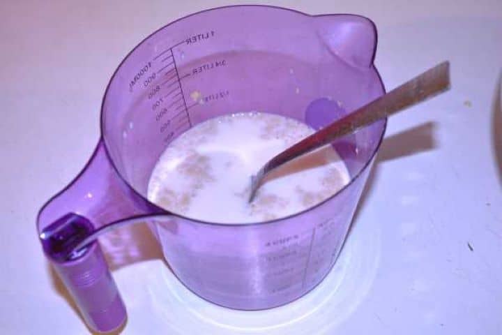 Milk and Yeast Dried yeast and sugar activating in warm milk inside a measuring cup until frothy.