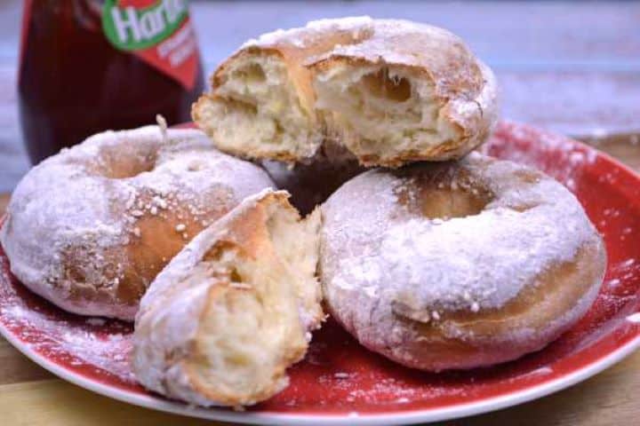 Served A batch of tender, pillowy air fryer doughnuts from scratch generously dusted with icing sugar.