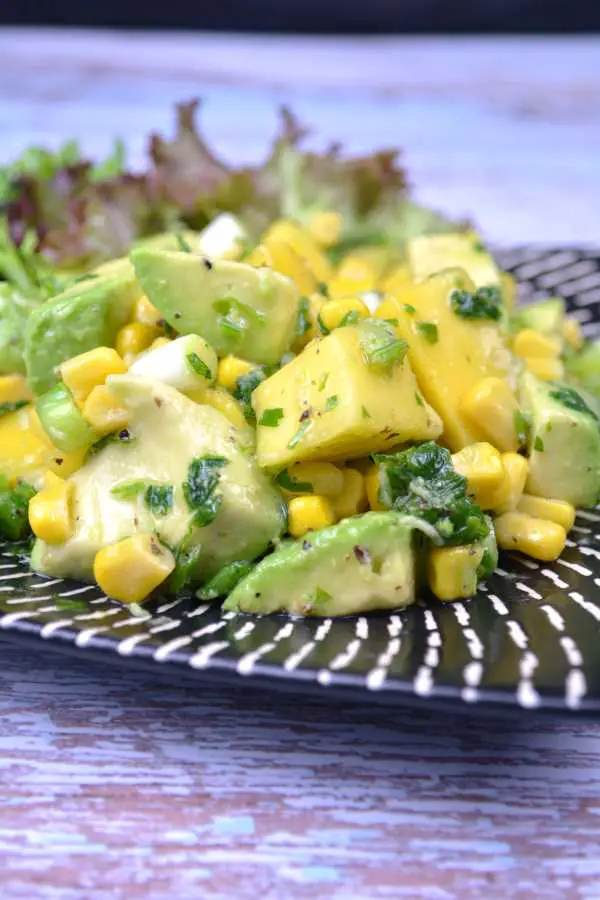 Avocado and Mango Salad-Served on Plate With Lemon Slices and Lettuce 