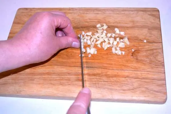 Chicken and Mushroom Alfredo-Chopping Garlic on the Chopping Board