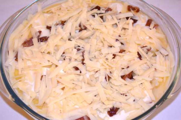Second Layer Bacon and Cheddar Top layer of polenta casserole finished with crispy bacon and shredded cheddar cheese ready for the oven.