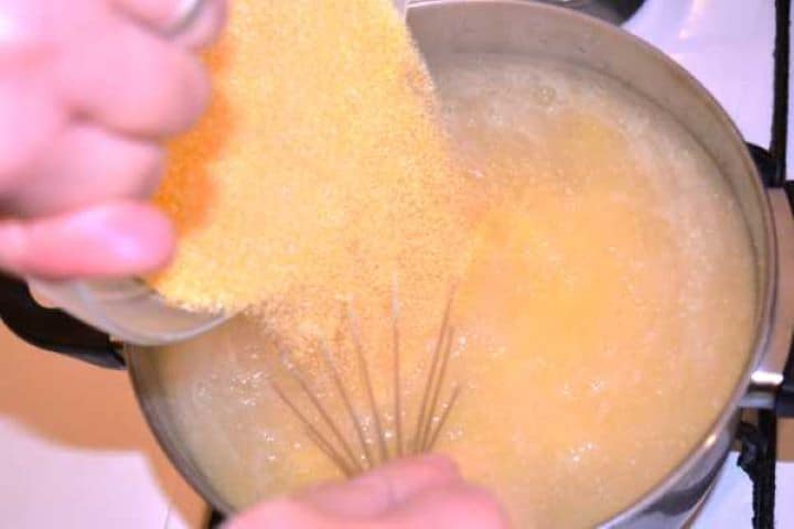 Cornmeal Pouring coarse cornmeal into a pot of boiling salted water while whisking continuously.