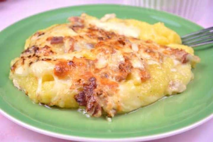 Serving Close-up of baked cheesy polenta showing gooey melted mozzarella layers and crispy bacon bits.