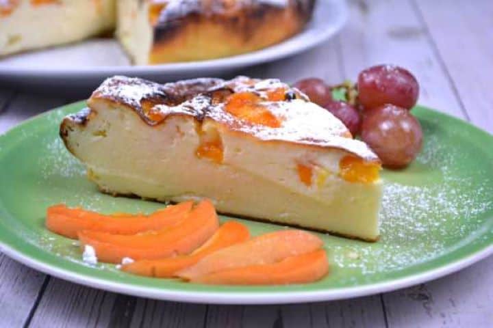 Serve A close-up slice of crustless flourless yoghurt cake on a dessert plate, showcasing its creamy, custard-like cheesecake texture.