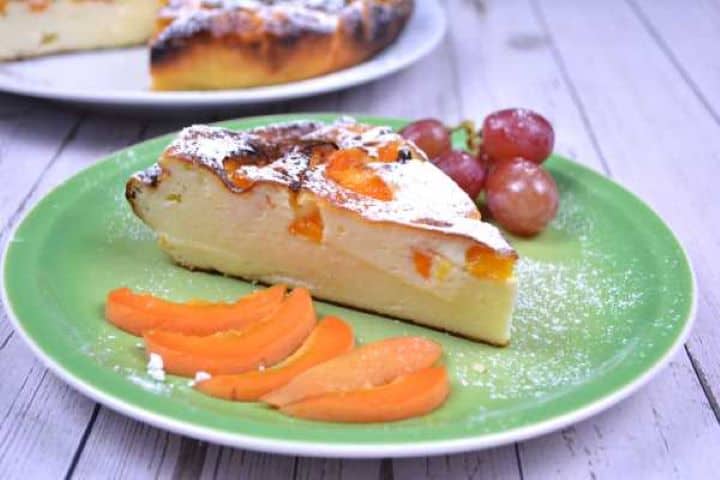 Served Gluten-Free Yoghurt Cake Slice Served on Green Plate With Apricot Slices and Grapes