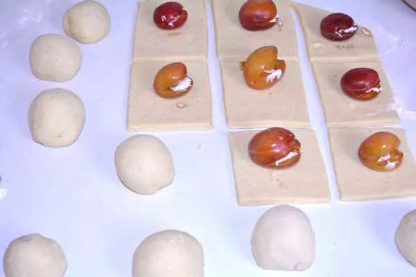 Hungarian Plum Dumplings-Dough Balls and Sugar Filled Plums on the Square Dough Shapes