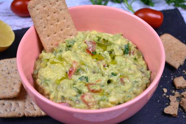Vegan Guacamole-Served in Pink Bowl With Crackers on the Table