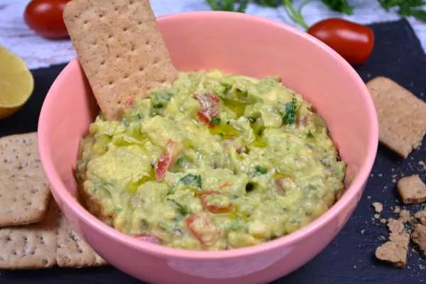 Vegan Guacamole-Served in Pink Bowl With Crackers on the Table