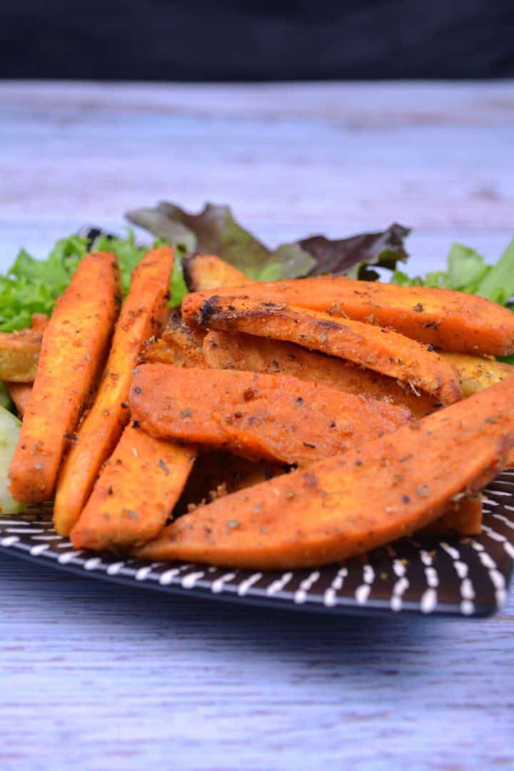 Serving A plate of crispy golden-brown air fryer sweet potato wedges seasoned with sweet Hungarian paprika and fresh herbs.