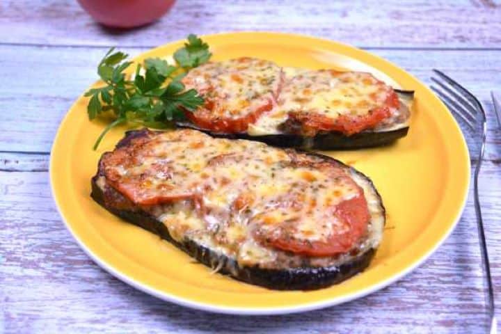 Serve Warm slice of oven-baked eggplant and pork mince served hot on a yellow ceramic plate.