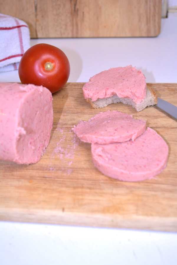 Chicken Salami Recipe-Three Salami Slices and One Tomato on the Chopping Board
