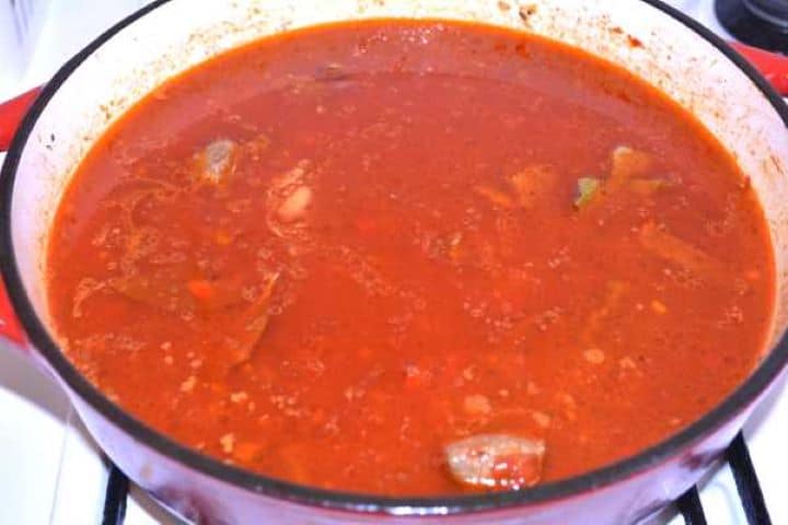 Simmering Hungarian beef paprikash simmering gently in vegetable broth in a cast iron pot.