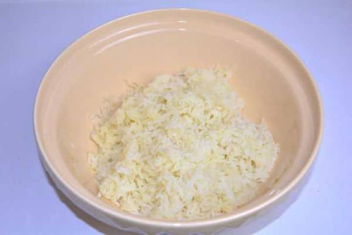 Mash Mashed starchy potatoes cooling in a mixing bowl to make tender potato dough.