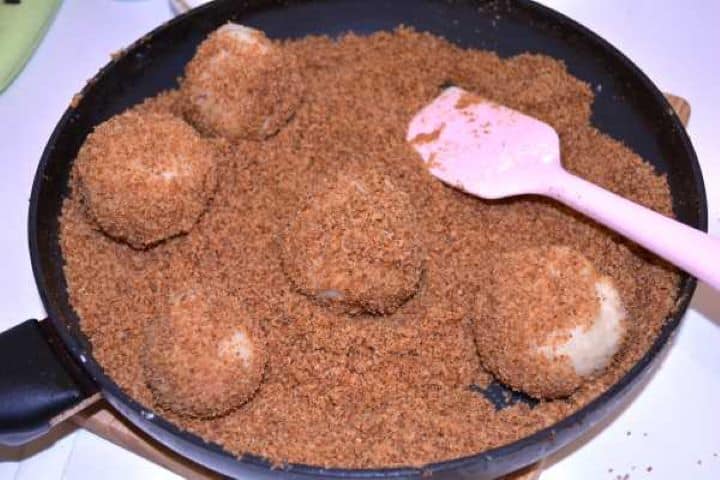 Coated Tossing boiled plum dumplings directly in butter-fried breadcrumbs in a skillet.