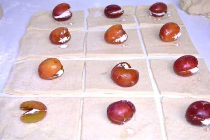 Filling Pitted Italian prune plums filled with cinnamon sugar resting on squares of potato dough.