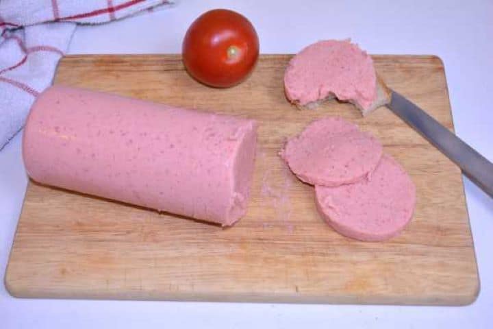 Slices of preservative-free homemade chicken salami arranged with fresh tomatoes for breakfast or sandwich filling.
